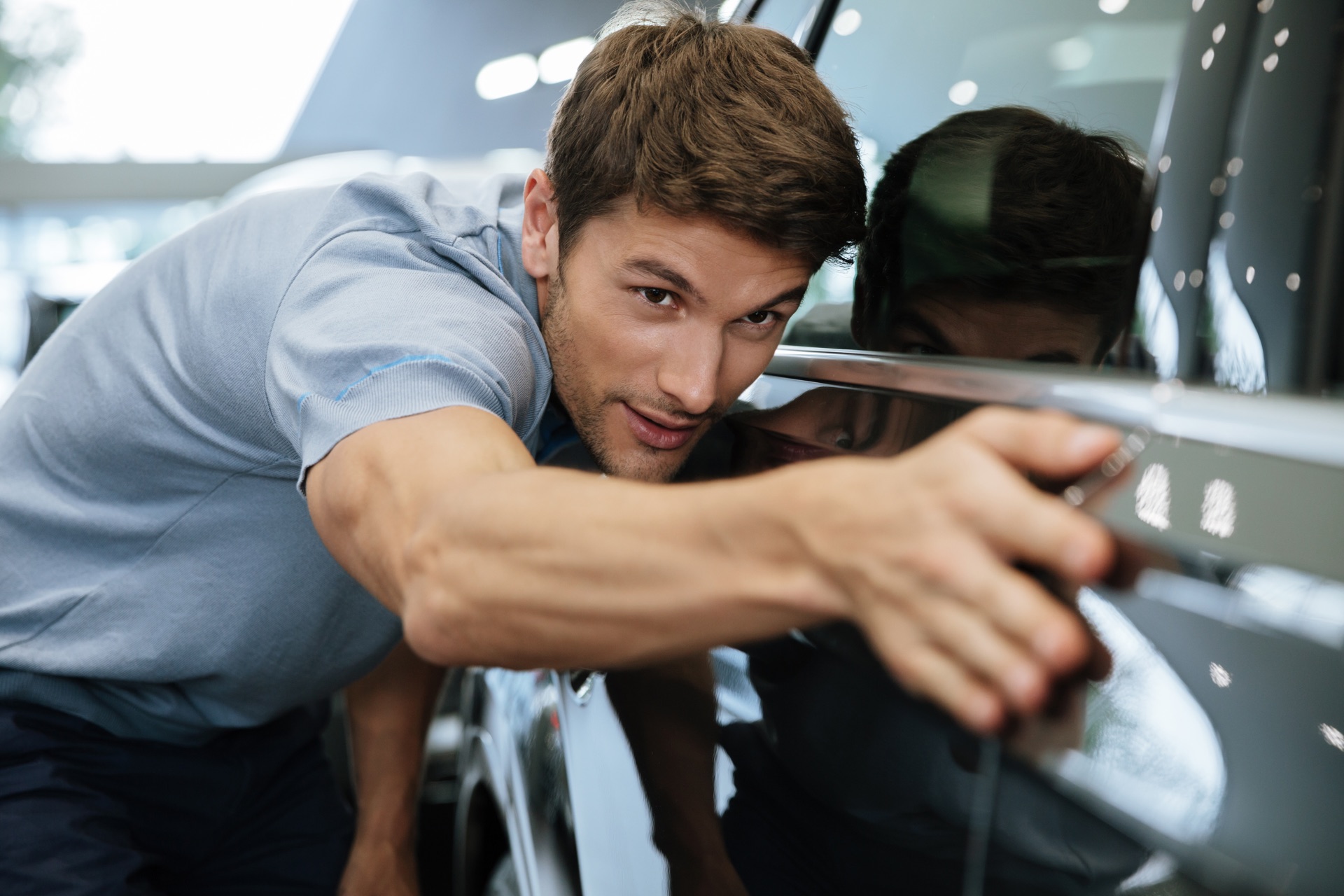 Een automakelaar inspecteert de lak van een auto